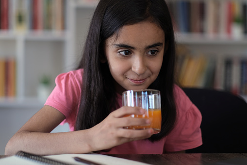 little girl sips orange juice