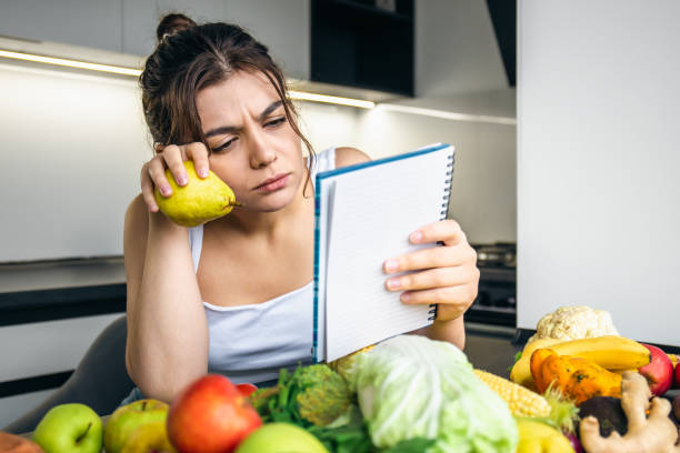 istock A young woman in the kitchen with a notebook among vegetables. 1428074122