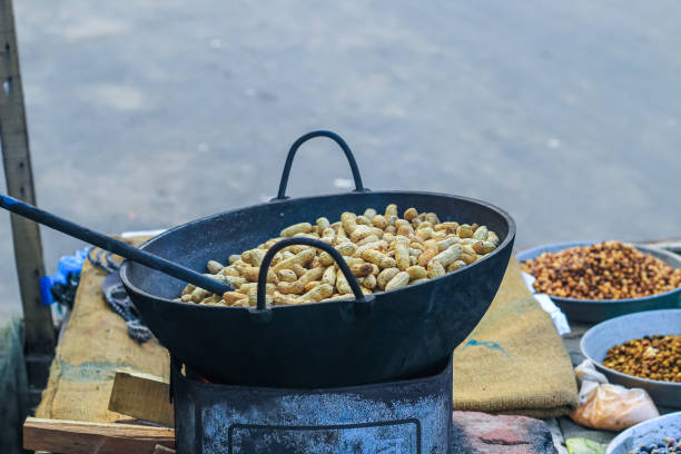 A peanut seller keep frying peanut on a van, fried peanuts.