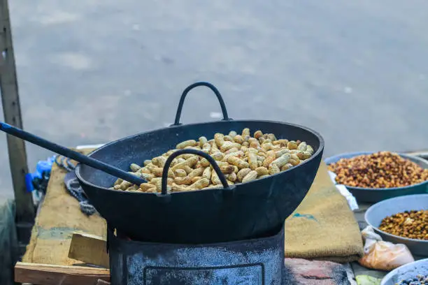 Photo of A peanut seller keep frying peanut on a van, fried peanuts.