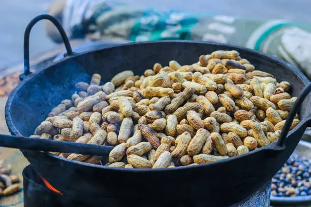 Photo of A peanut seller keep frying peanut on a van, fried peanuts.