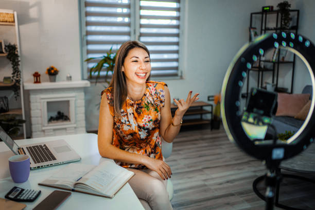istock Smiling woman filming a educational video on her phone with ring light 1428076364