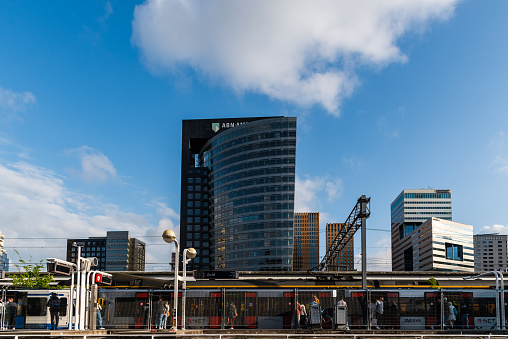 Amsterdam, Netherlands - May 7, 2022: ABN Amro Bank skyscraper and Amsterdam Zuid station. Contemporary architecture, blue colors. Low angle view