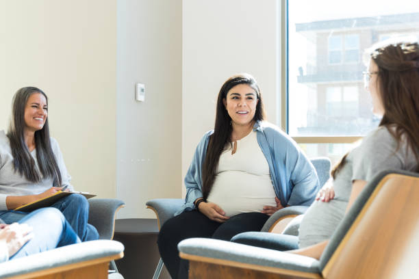 istock Female counselor smiles as expectant moms share in support group 1428081303
