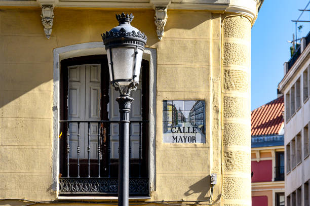 Madrid, Spain - September 15, 2022: View of a street lamp in front of the facade of a building. A sign on the building says \