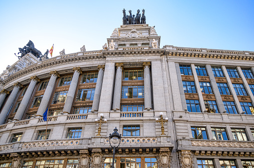 Madrid, Spain - September 15, 2022: Close-up of the exterior of a large building. There are some horse statues of horses on the roof of the building, and no people are on the scene.