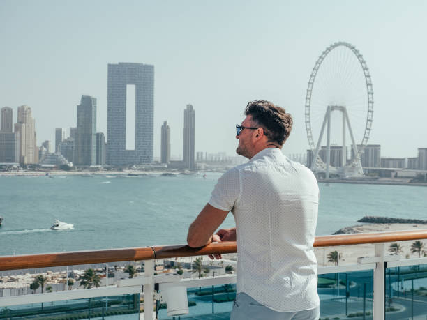 Fashionable man standing on the empty deck Fashionable man standing on the empty deck of a cruise liner against the backdrop of the setting sun. Closeup, outdoor. Vacation and travel concept arabian sunglasses stock pictures, royalty-free photos & images