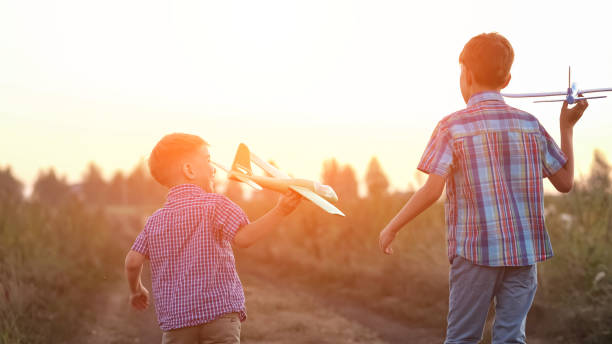 istock Boy siblings run past fields to launch airplanes to sky 1428087050