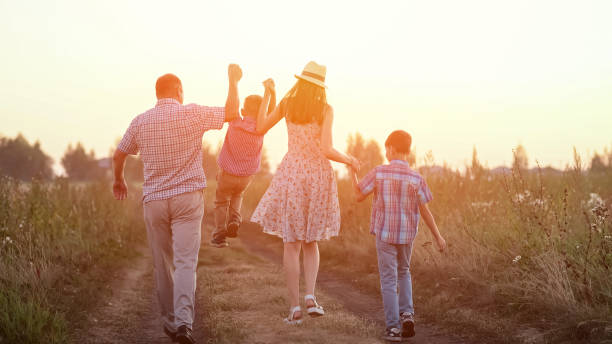 istock Parents playing with boys kids walk among wheat fields 1428087059