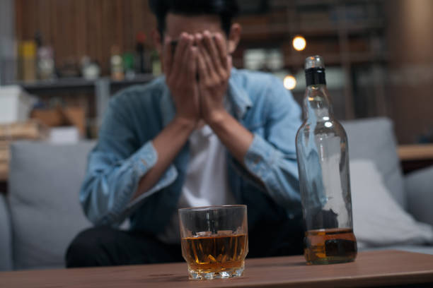 alcolismo o concetto alcolico : chiudi il giovane ragazzo asiatico che si sente depresso bevendo alcolici da solo in un pub o in un bar perché problemi di vita o stress. - alcolismo foto e immagini stock