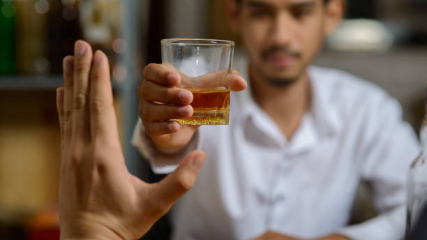 Asian man refusing alcohol from friend or another person because he want to quit drinking or will drive a vehicle. Asian man refusing alcohol from friend or another person because he want to quit drinking or will drive a vehicle. alcoholic drinl stock pictures, royalty-free photos & images
