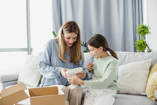 Cheerful mother and daughter excited to see their online purchase