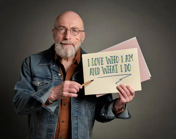 I love who I am and what I do - positive affirmation words presented by a senior confident and happy man