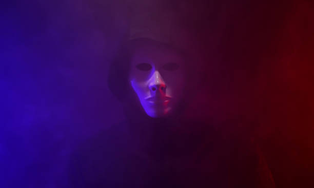 Man wearing mask with hoodie on neon background. Man wearing mask with hoodie on neon background. vendetta stock pictures, royalty-free photos & images
