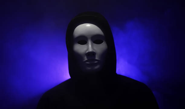 istock Man wearing mask with hoodie on blue background. 1428094233