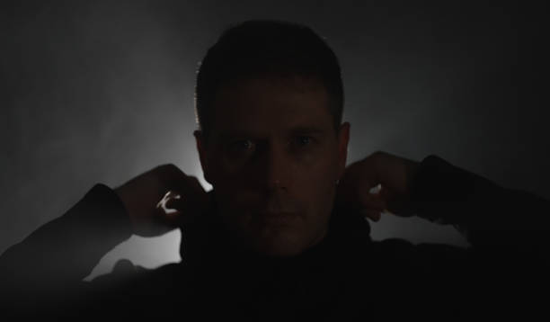istock Handsome man puts on black hoodie. 1428094257