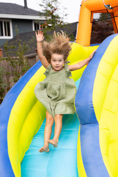 istock young girl jumping down blowup slide 1428102328