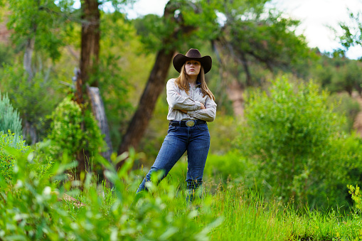 Outdoor Cowgirl Portraits - Young lady dressed in western country attire outdoors in natural beautiful area.