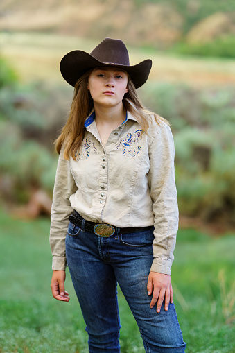 A portrait of a beautiful young cowgirl standing outdoors in the sunhttp://195.154.178.81/DATA/i_collage/pi/shoots/783576.jpg