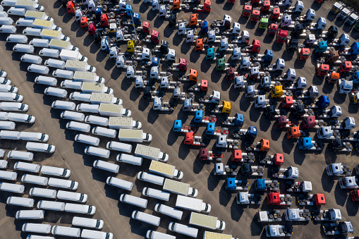 Tractor units of trucks and delivery vans parked close together, viewed directly from above.