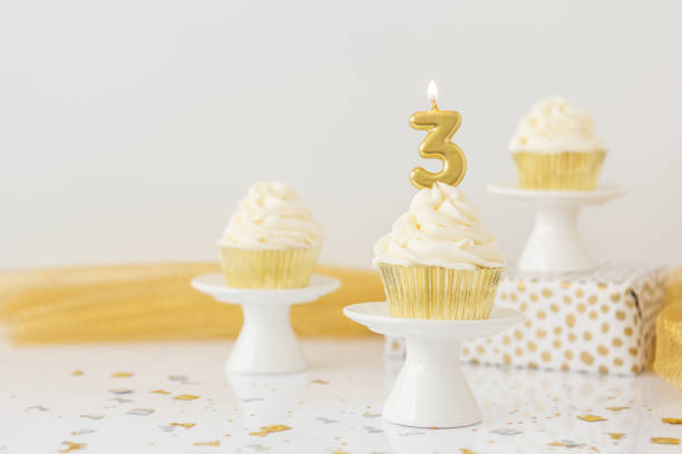 istock Birthday Candle 3 on Vanilla Cupcake 1428104923