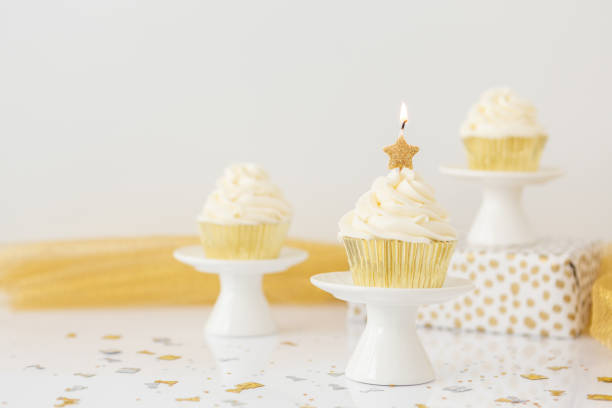 istock Gold Star Candle on Vanilla Cupcake 1428104929