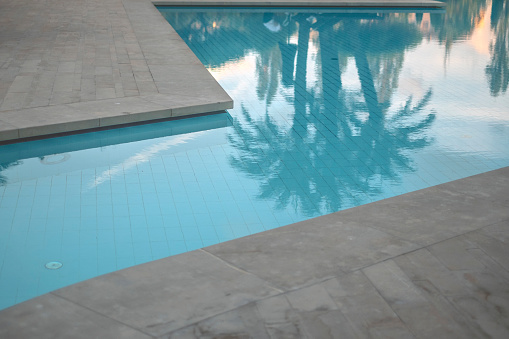 blue swimming pool with teak wood flooring stripes summer vacation