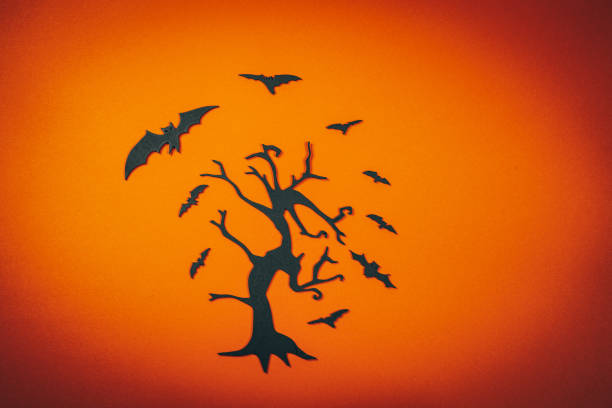 Black carved tree with flying bats.