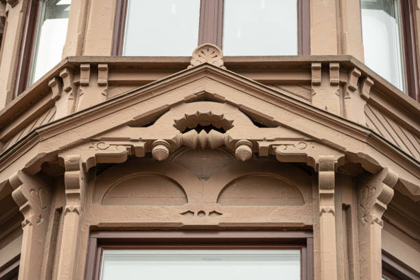 carved out decorations above a corner window of a house..