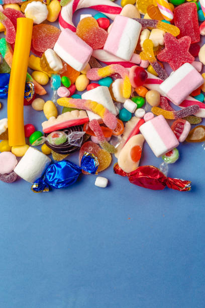 istock Colorful candies on table on blue background 1428112830