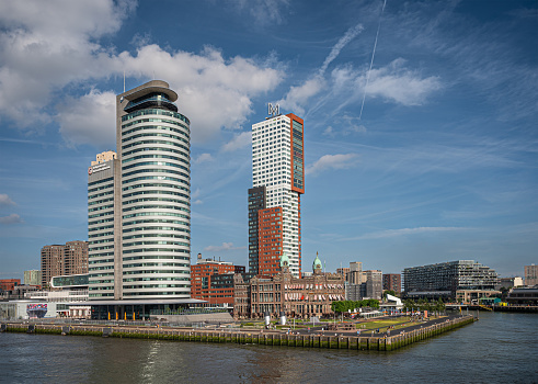 Rotterdam, Netherlands - July 11, 2022: World Port Center andminstrative building of Port Authority under blue cloudscape on Kop of Zuid dock. Other high rises and New York hotel