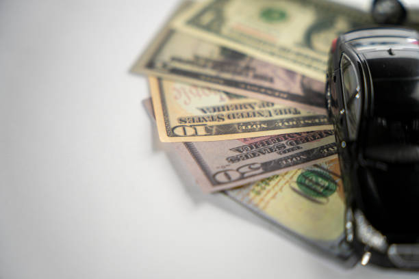 A handgun placed on top of a two-dollar bill, symbolizing the connection between money and violence. This image can represent themes of crime, financial desperation, or the cost of security