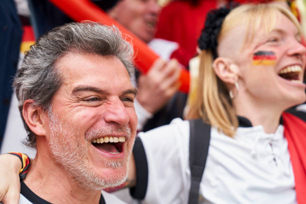 Euphoric German man shouting and celebrating at Germany national team match Medium shot of euphoric German man shouting and celebrating at Germany national team match in crowded stadium women under 20 stock pictures, royalty-free photos & images