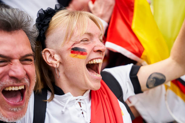 Euphoric German football fan with painted face celebrating Germany's national team goal Mid-shot of euphoric German football fan with painted face celebrating Germany's national team goal in crowded stadium women under 20 stock pictures, royalty-free photos & images
