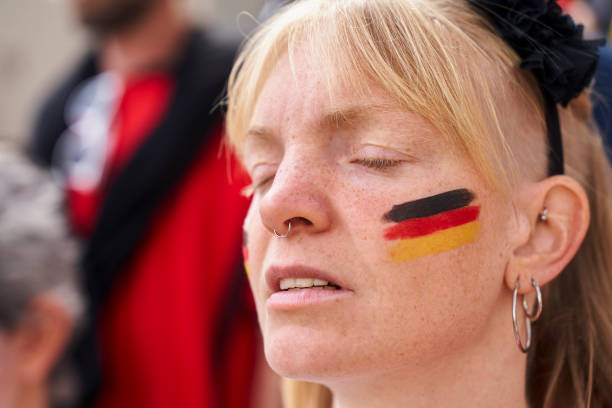 German woman with closed eyes at Germany national team game Close-up shot of German woman with face paint and closed eyes at Germany national football team match in crowded stadium women under 20 stock pictures, royalty-free photos & images