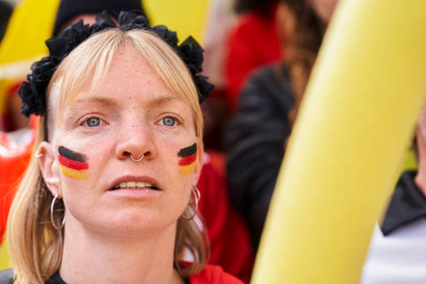 German football fan with worried look watching Germany national team Mid-shot of German football fan wearing face paint and looking worried while watching Germany national team at crowded stadium women under 20 stock pictures, royalty-free photos & images