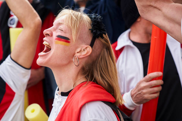 Euphoric German woman chanting and celebrating after national team scores goal Mid-shot of euphoric German woman chanting and celebrating in crowded stadium after national team scores goal women under 20 stock pictures, royalty-free photos & images