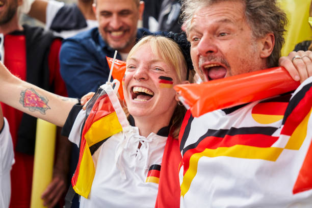 Ecstatic German football fans celebrating after national team scores goal Medium shot of ecstatic German football fans wearing Germany national team jerseys celebrating after team scores goal in crowded stadium women under 20 stock pictures, royalty-free photos & images