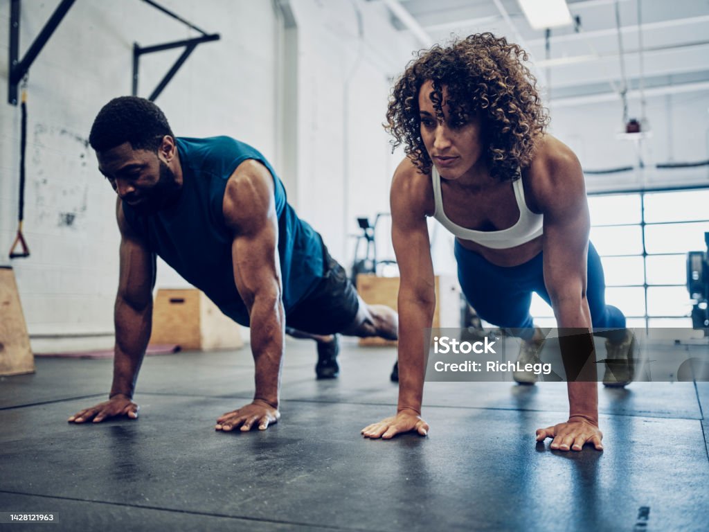 Two People Cross Training in a Gym An athletic couple cross training in a gym. Women Stock Photo