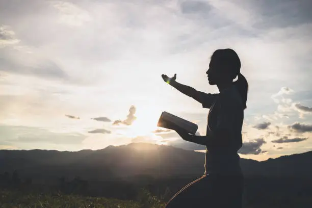 Photo of Silhouette of The girl  prayed  in the mountains to think of a loving God, we praise God.