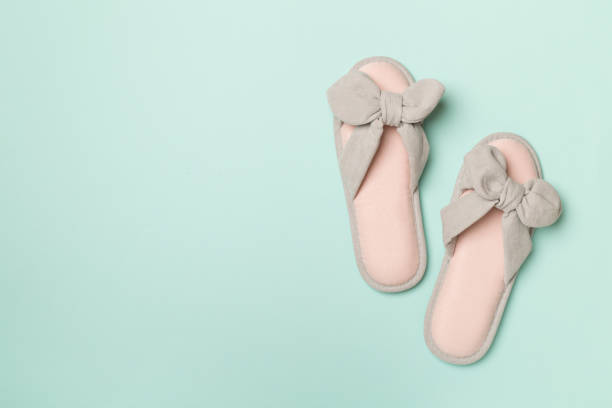 istock Soft pink slippers on color background, top view 1428123771