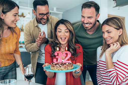 Young woman celebrating her 32nd birthday with friends at home