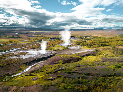 Strokkur is a fountain-type geyser located in a geothermal area beside the Hvítá River in Iceland. Two geysers erupting at once is a once in a lifetime possibility to capture it. Aerial drone view