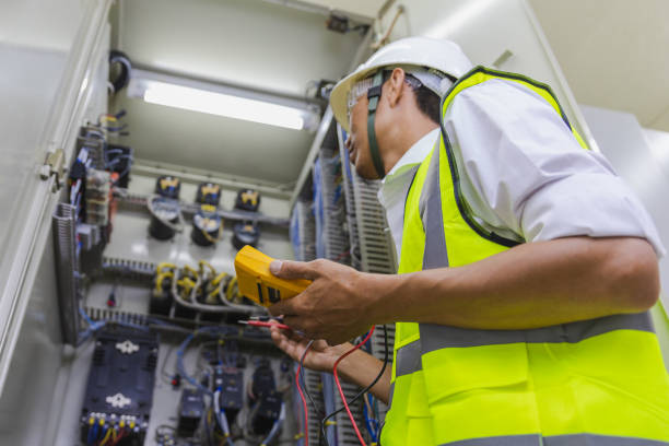 electrician installing electric cable wires and fuse switch box. multimeter in hands of electricians detail.electrician repairing electrical control cabinets. - meter electric meter electricity fuel and power generation imagens e fotografias de stock