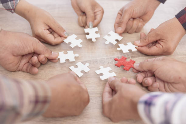 istock A group of business people assembling jigsaw puzzle. The concept of cooperation, teamwork, help and support in business. Team business success partnership. 1428131615