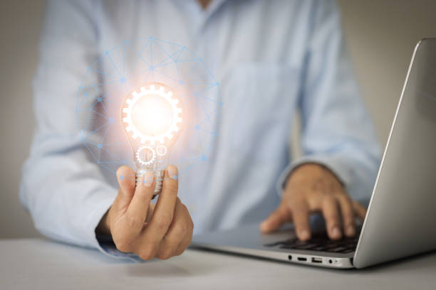 istock The hand of a man with a light bulb And there is a gear icon in it And he is using a notebook computer.  Idea concept with innovative technology, Brainstorming creativity, idea thinking. 1428131619