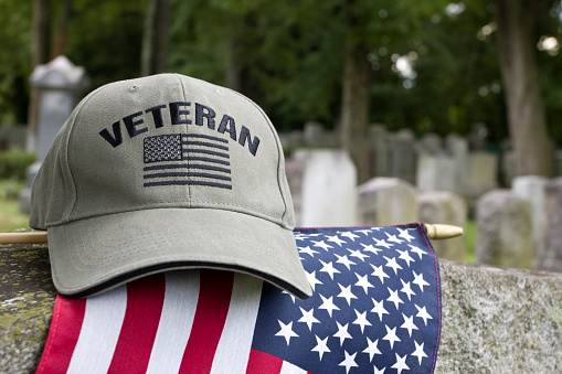 Veteran’s cap on grave markers in cemetery.