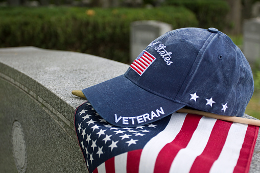 Veteran’s cap on grave markers in cemetery.