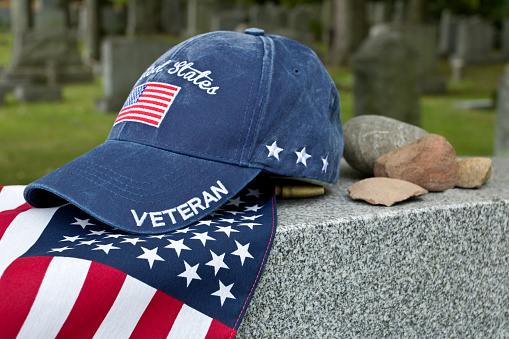 Gorra de veteranos estadounidenses en la bandera y marcador de la tumba en el cementerio judío photo