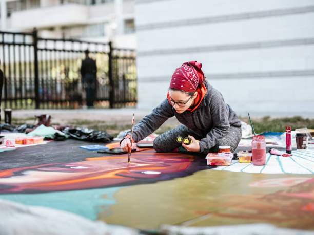 istock Young Latin woman creating outdoor mural 1428150716